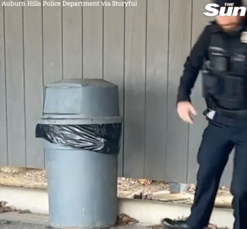ゴミ箱から距離を取る警察官